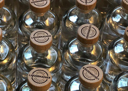 Mehrere Glasflaschen Liquormacher Gin bei Herstellung und Verpackung